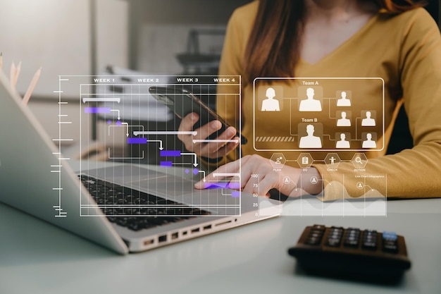Mano de mujer Gerente de proyecto trabajando y actualizando tareas y diagrama de Gantt programando diagrama virtual con teléfono inteligente y computadora portátil en la oficina