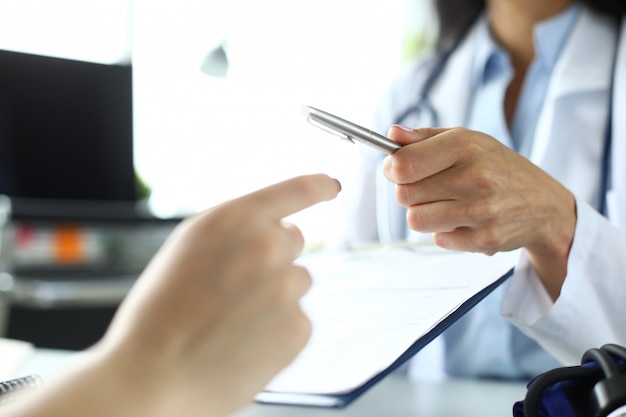 Mano de mujer GP pasando a paciente pluma de plata