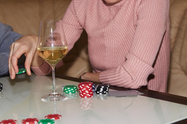 Mano de mujer haciendo un movimiento con dados en el juego de póquer Dados de cartas y copas de champán Momento sincero Fotografía de estilo de vida de fondo de póquer Disfrutando el momento de desintoxicación digital con amigos