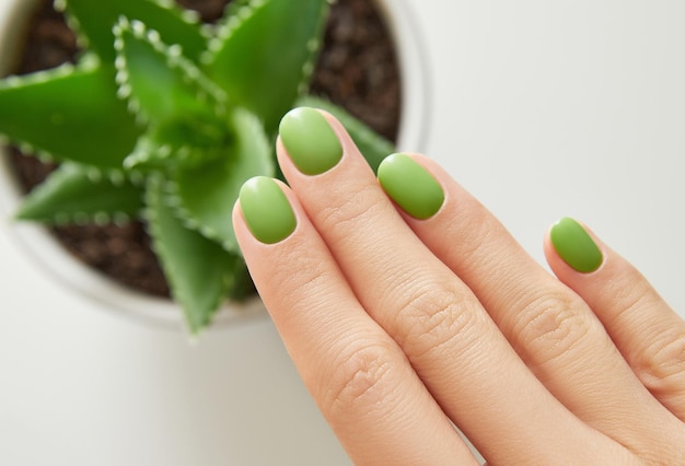 Mano de mujer hermosa con diseño de uñas de verano sobre fondo blanco Primer plano concepto de salón de belleza de manicura pedicura laico