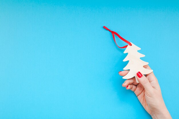 Mano de mujer con juguete de Navidad de madera casero