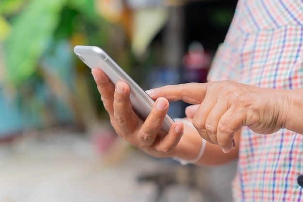 Mano de mujer madura sosteniendo smartphone