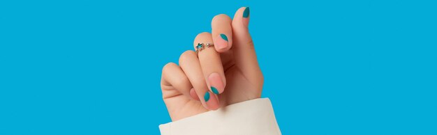 Mano de mujer con manicura azul diseño de uñas de moda primavera verano