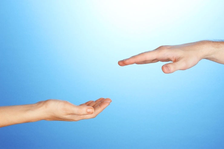 Foto la mano de la mujer va a la mano del hombre sobre fondo azul.