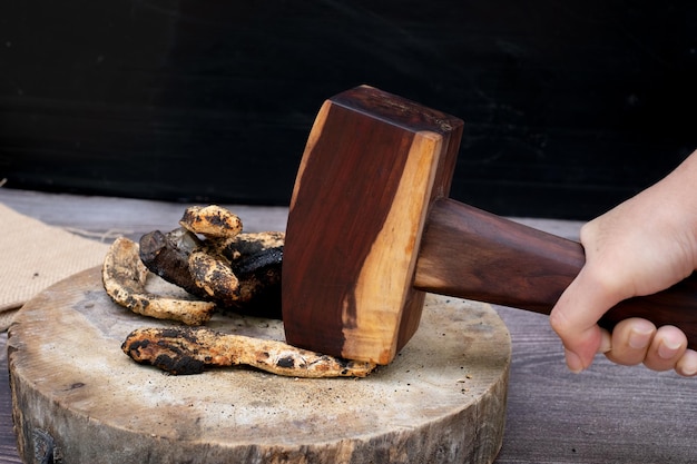 La mano de la mujer con el martillo se estrelló contra el cuero de ante a la parrilla.