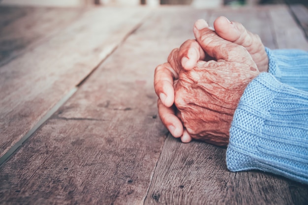 Foto la mano de la mujer mayor. concepto dramático de soledad, tristeza, depresión, emociones tristes, llanto, desilusión, cuidado de la salud, dolor.