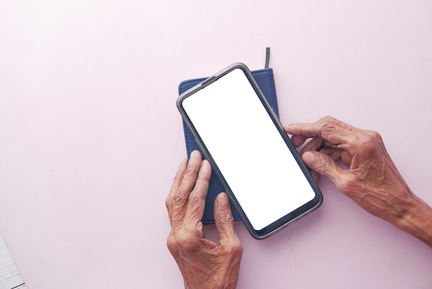 mano de mujer mayor con teléfono inteligente cerrar