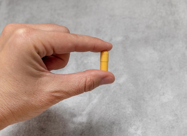 mano de mujer con muchas tabletas de pastillas en la palma de diferentes colores y formas cápsulas una pastilla en la niña