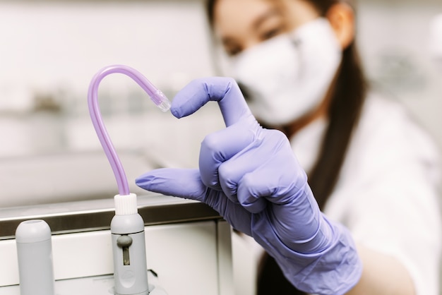 La mano de la mujer muestra el corazón junto con el eyector de saliva.