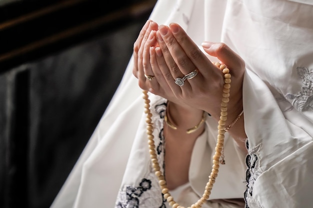 Mano de mujer musulmana rezando por las bendiciones de Alá en la mezquita de Ayutthaya