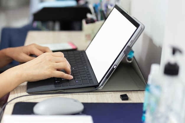 Mano de mujer de negocios escribiendo en el teclado de la computadora portátil en casa