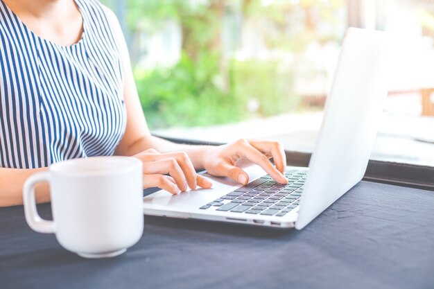 Mano de mujer de negocios trabajando con una computadora portátil en la oficina