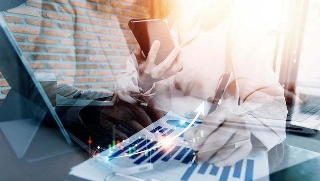 Mano de mujer de negocios trabajando con tableta de computadora portátil y teléfono inteligente en la oficina moderna con diagrama de icono virtual en la oficina moderna a la luz de la mañana