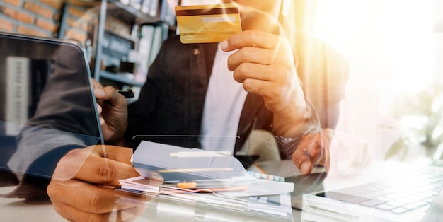 Mano de mujer de negocios usando pagos de tableta de teléfono inteligente y sosteniendo tarjeta de crédito compras en línea tableta digital omnicanal acoplando computadora de teclado en la oficina a la luz del sol