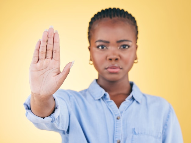 Mano de mujer negra y parada de advertencia y precaución en retrato con comunicación aislada en fondo amarillo Emoji de gesto y palma censurada y ninguna entrada con lucha de protesta y conflicto en el estudio