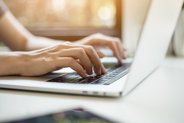 La mano de la mujer presiona el teclado de la laptop.