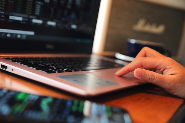 Mano de la mujer que trabaja en la mano de la cafetería en el teclado con cierre para arriba