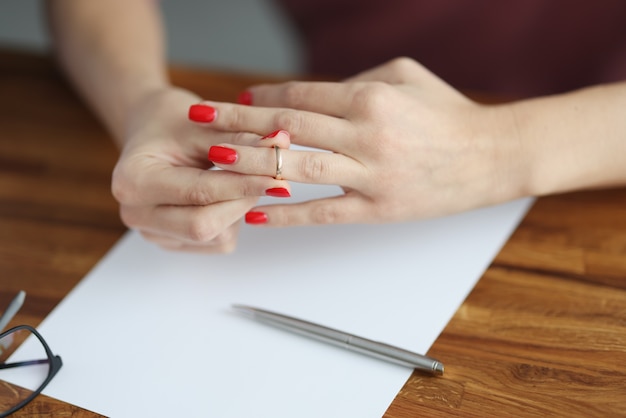 La mano de la mujer quita el anillo de bodas de su dedo