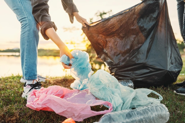 Mano de mujer recogiendo plástico de basura para limpiar en parkxA