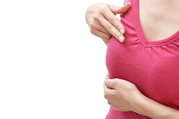 Mano de mujer revisando bultos en su pecho para detectar signos de cáncer de mama