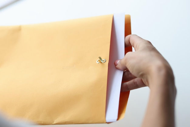 La mano de la mujer saca la carta del sobre que recibe el concepto de correo
