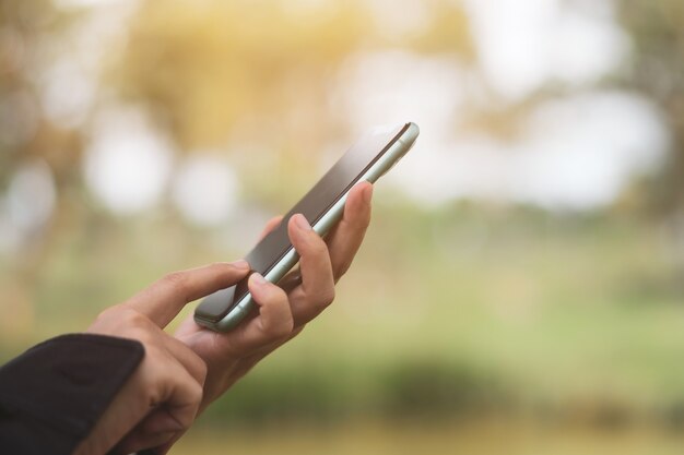 Mano de mujer con smartphone para hacer negocios, redes sociales, concepto de comunicación.