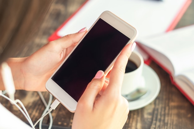 Mano de mujer con smartphone con pantalla negra