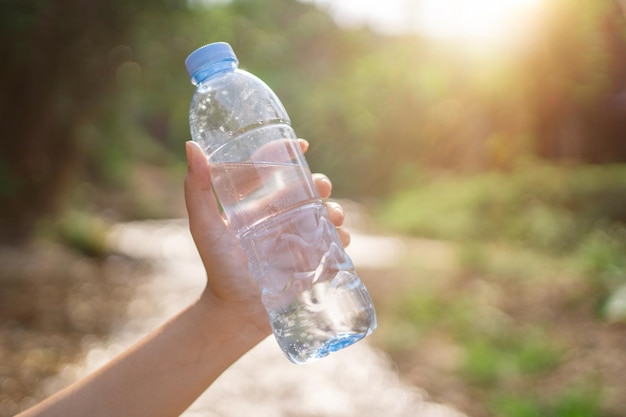 Mano de mujer sosteniendo una botella de plástico