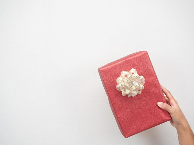 Mano de mujer sosteniendo una caja de regalo roja en el espacio de copia de fondo blanco