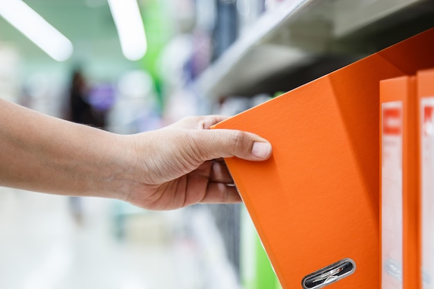 Mano de mujer sosteniendo la carpeta