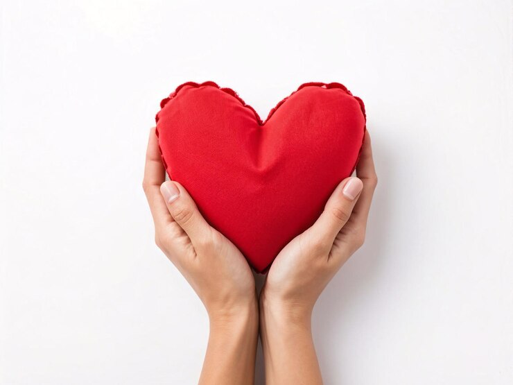 una mano de mujer sosteniendo un corazón rojo