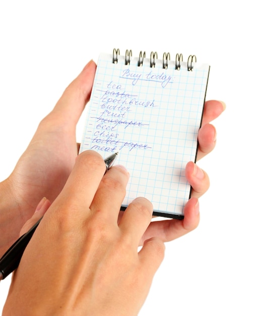 Mano de mujer sosteniendo un cuaderno con un primer plano de lista de compras