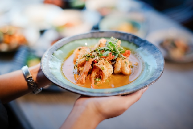 Foto la mano de una mujer sosteniendo una ensalada de camarones