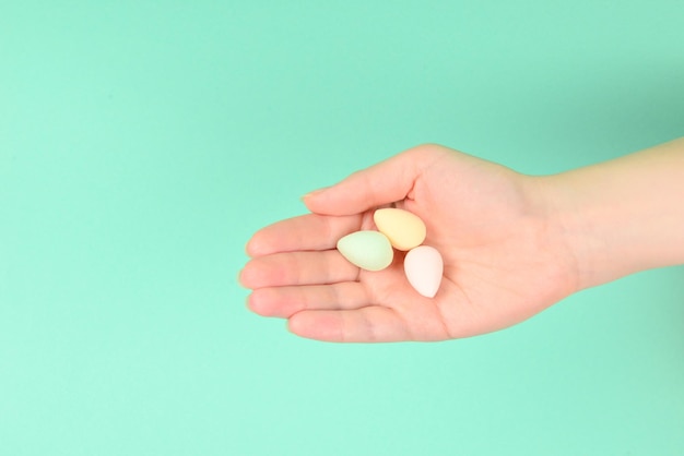 Mano de mujer sosteniendo esponja de belleza sobre fondo verde