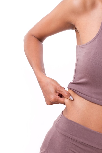 mano de mujer sosteniendo grasa abdominal excesiva