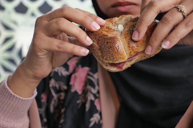 Mano de mujer sosteniendo hamburguesa de ternera