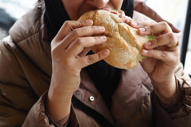 Mano de mujer sosteniendo hamburguesa de ternera