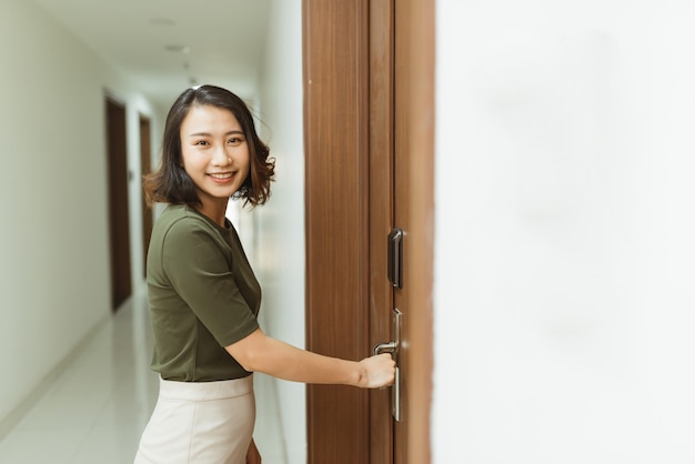 Mano de mujer sosteniendo las manijas de las puertas modernas cerradura electrónica abrir la puerta del apartamento
