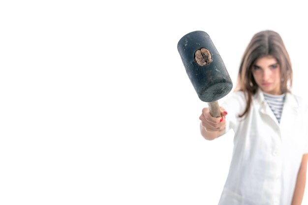 Mano de mujer sosteniendo un martillo sobre fondo blanco.