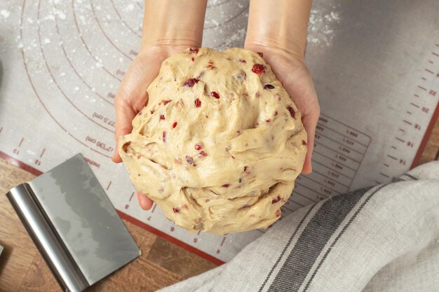 Mano de mujer sosteniendo masa de pan con vista superior de arándano