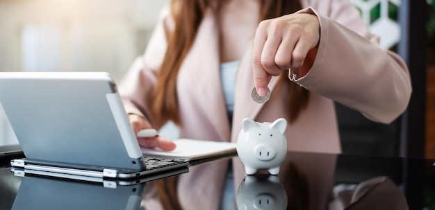 Mano de mujer sosteniendo moneda con hucha de cerdo ahorro y concepto financiero