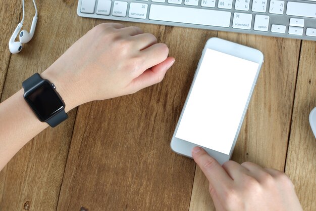 mano de mujer sosteniendo la pantalla vacía de teléfonos inteligentes