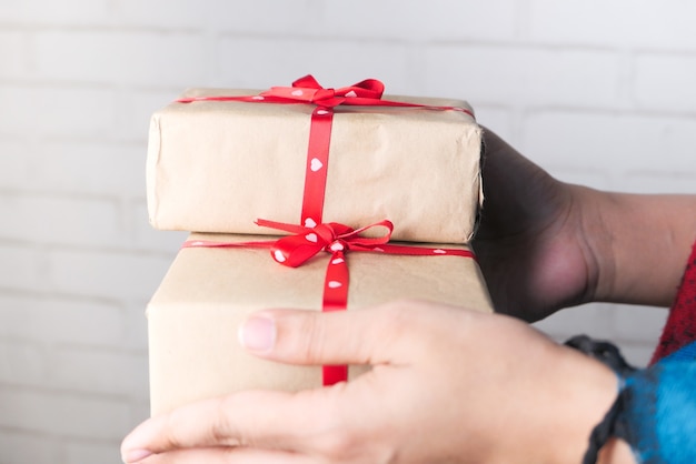 Foto mano de mujer sosteniendo la pila de caja de regalo