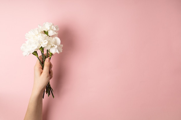 Mano de mujer sosteniendo ramo de flores