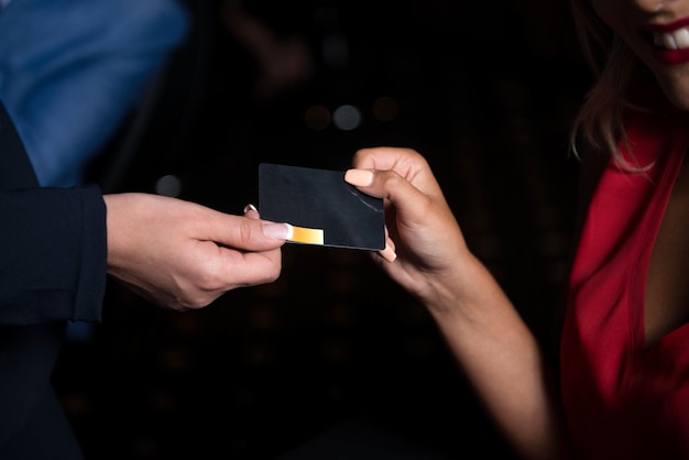 Mano de mujer sosteniendo una tarjeta vip jugando en el casino