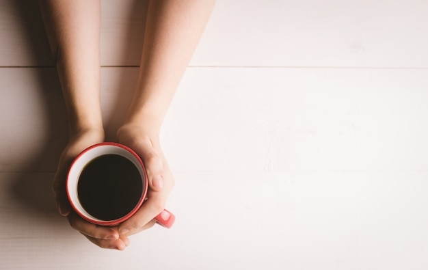 Mano de mujer sosteniendo la taza de café