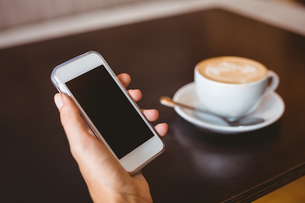 Mano de mujer sosteniendo teléfono inteligente