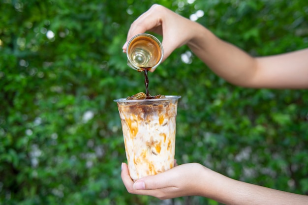 Foto mano de mujer sosteniendo el vaso de café helado