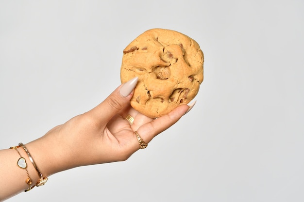 Foto la mano de una mujer sostiene una galleta de mantequilla de maní.