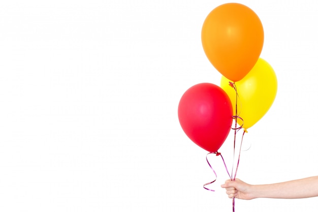 La mano de la mujer sostiene globos en un fondo blanco